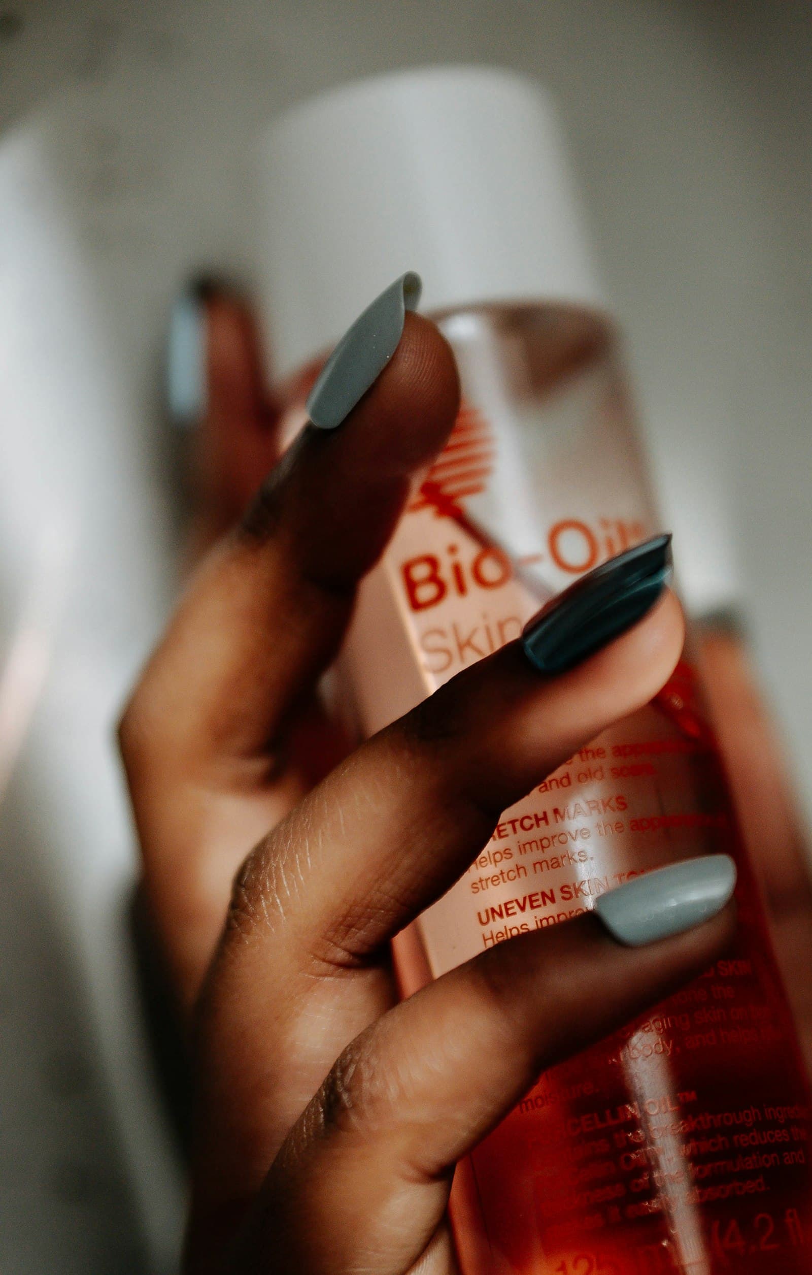 Flacon d'huile de soin cosmétique tenu à la main